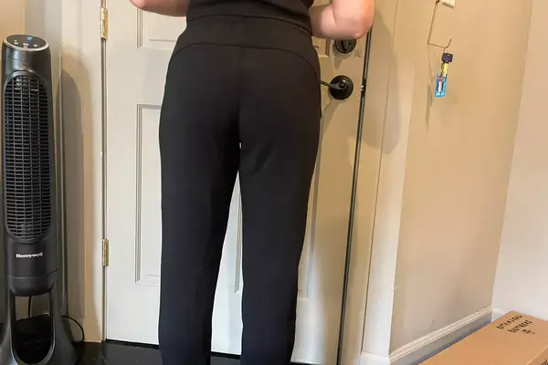 A person lifts their shirt to show the back of the Spanx AirEssentials Tapered Pant