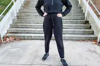 A person wearing the Spanx AirEssentials Tapered Pant outside in front of stairs