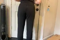 A person lifts their shirt to show the back of the Spanx AirEssentials Tapered Pant