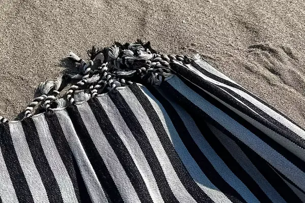 A close up of the Fairmont Turkish Linen Towel on a beach