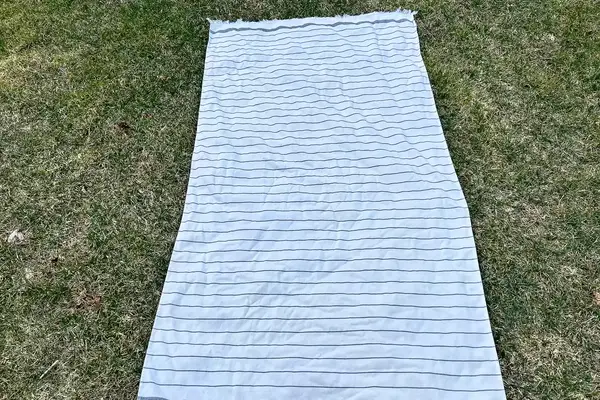 Brooklinen Turkish Flatweave Beach Blanket laying on the grass