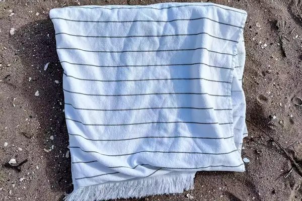 Brooklinen Turkish Flatweave Beach Blanket on a beach