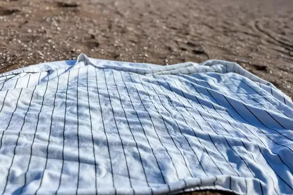 Brooklinen Turkish Flatweave Beach Blanket on a beach