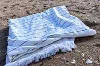 Brooklinen Turkish Flatweave Beach Blanket on a beach