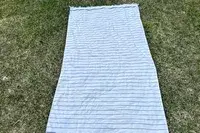 Brooklinen Turkish Flatweave Beach Blanket laying on the grass