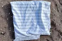 Brooklinen Turkish Flatweave Beach Blanket on a beach