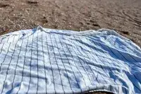 Brooklinen Turkish Flatweave Beach Blanket on a beach