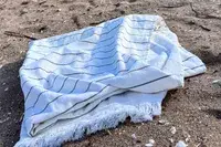 Brooklinen Turkish Flatweave Beach Blanket on a beach
