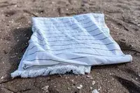 Brooklinen Turkish Flatweave Beach Blanket on a beach