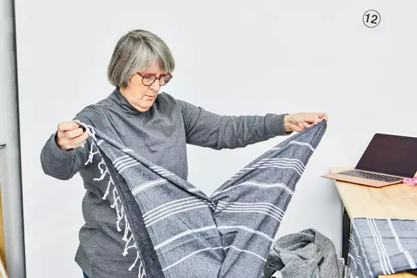 A person unfolding the Cacala 100% Organic Cotton Pestemal Turkish Bath Towel