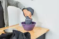 A person dipping the Cacala 100% Organic Cotton Pestemal Turkish Bath Towel into a purple bowl