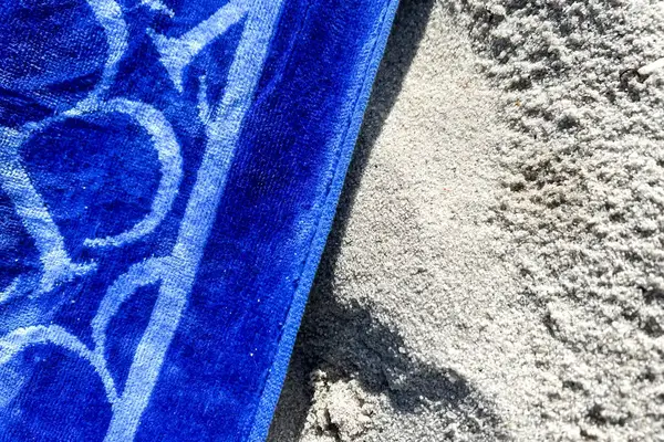 A close-up of the Boll & Branch The Beach Towel on sand