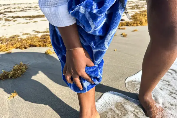 A person drying their leg with the Boll & Branch The Beach Towel