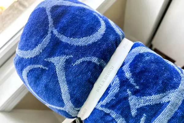 The Boll & Branch The Beach Towel in a strap near a window