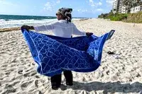 A person fanning out the Boll & Branch The Beach Towel
