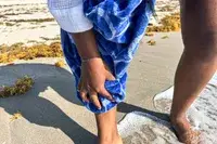 A person drying their leg with the Boll & Branch The Beach Towel