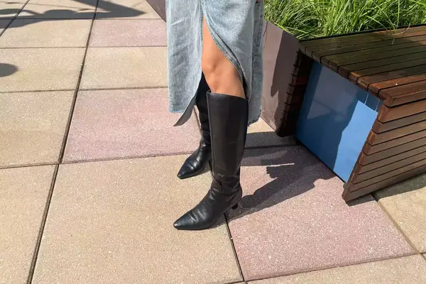 A person wears the Naturalizer Deesha Knee High Boot outside 