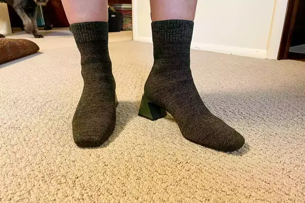 A person stands inside while wearing the Vivaia Regina Pro Square-Toe Water-Repellent Heeled Boots