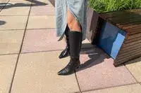 A person wears the Naturalizer Deesha Knee High Boot outside 
