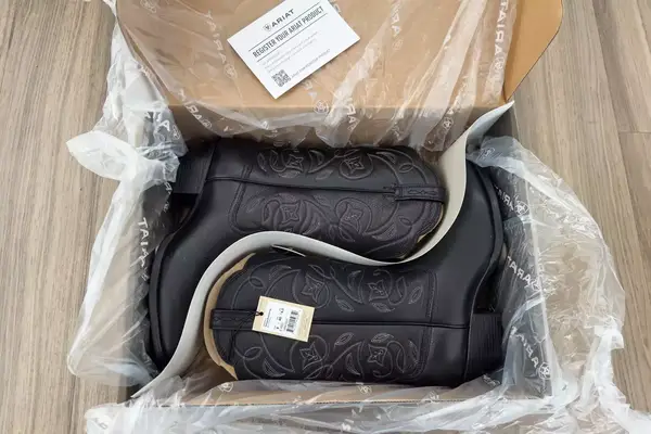 A pair of Ariat Heritage R Toe Western Boots in a box