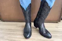 A front view of a person wearing the Ariat Heritage R Toe Western Boots