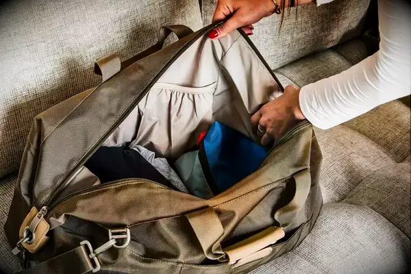 A person holding open a filled Briggs & Riley Weekender Duffle