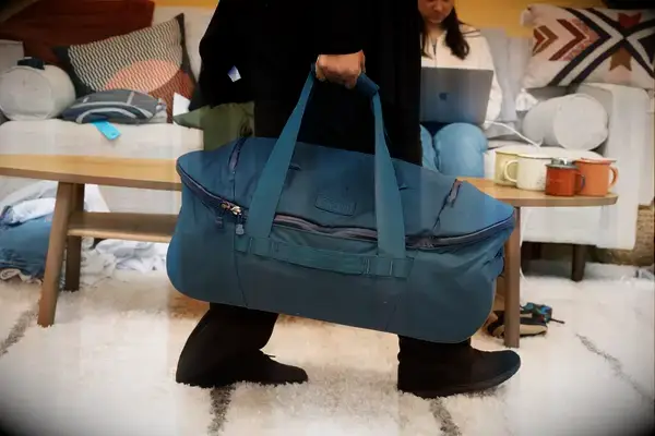 Hand putting a passport in the Bellroy Classic Weekender 45L