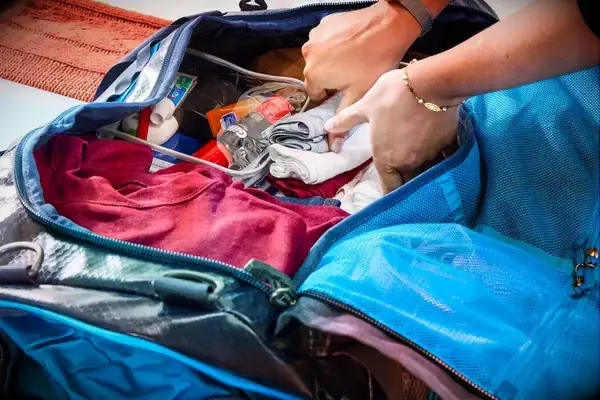 A person packing the Gregory Alpaca Duffel 60