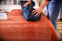 A person folding the Gregory Alpaca Duffel 60