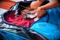 A person packing the Gregory Alpaca Duffel 60