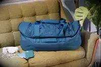 YETI Crossroads Duffel Bag 60L on a couch next to a phone
