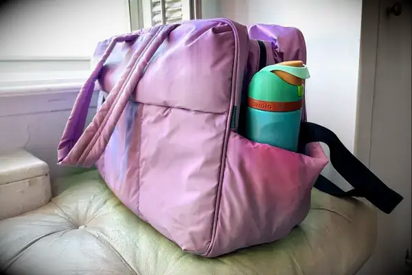 A water bottle in the side pocket of the Calpak Luka Large Duffel