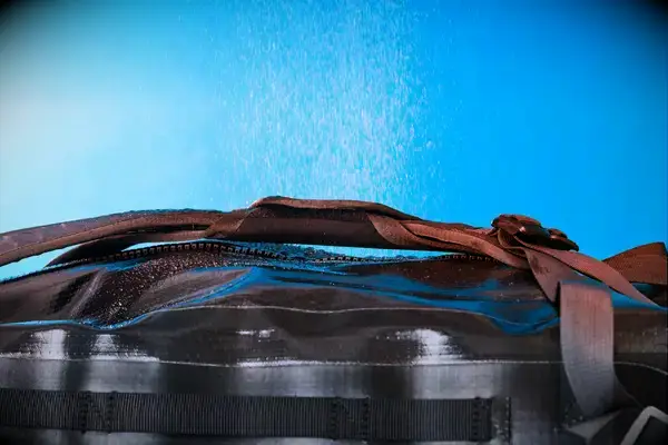 Water is sprayed on the Osprey Transporter Waterproof Duffel 70L