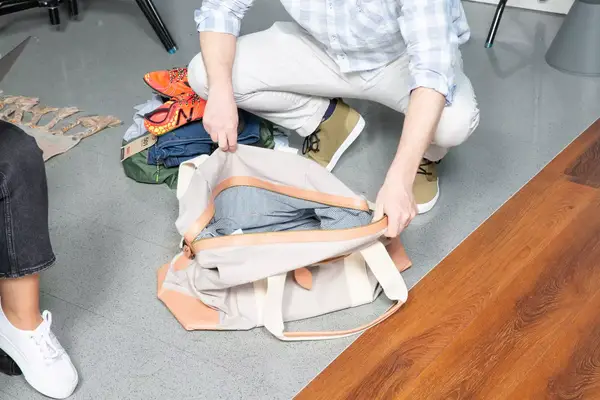 Man opening the Mark & Graham Canvas and Leather Weekender
