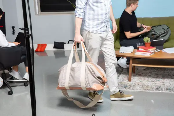 Man holding straps of the Mark & Graham Canvas and Leather Weekender