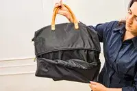A person unzips the Mark & Graham Terminal 1 Expandable Travel Tote