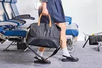 A person carries the Mark & Graham Terminal 1 Expandable Travel Tote