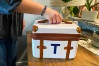 A person holds up the Mark & Graham Terminal 1 Cosmetic Case