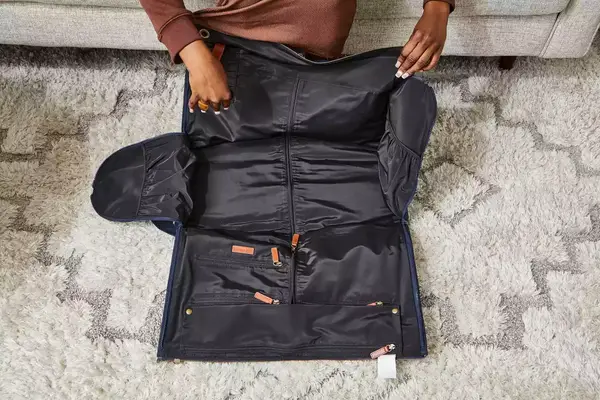 Hands opening the Mark & Graham Commuter 2-in-1 Garment Bag