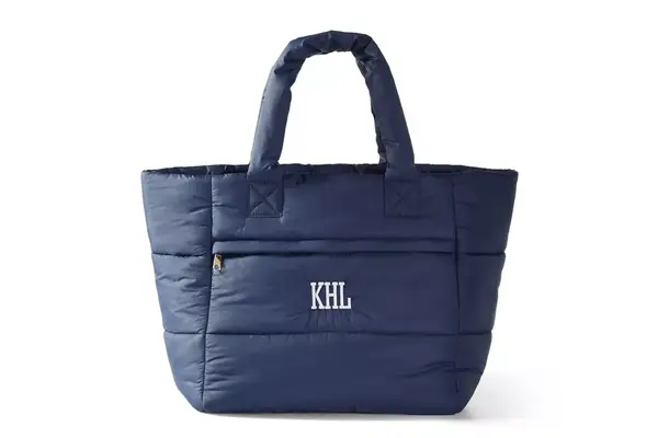 A person packs the Mark & Graham Terminal 1 Checked Rolling Duffle Bag