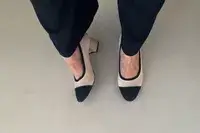 Feet wearing the Vivaia Round-Toe Chunky Heels (Julie Pro) on white floor