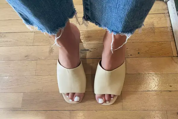 A person standing on wood floor with the Aerosoles Entree Shoe on their feet