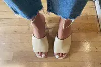 A person standing on wood floor with the Aerosoles Entree Shoe on their feet