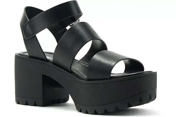 Closeup of feet wearing the Nine West Kuna 9x9 Pointy Toe Pumps on wood flooring