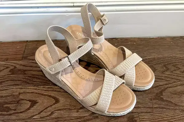 The Vivaia Round Toe Wedge Sandals sitting on a wood floor