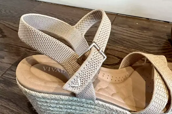 A close up of the Vivaia Round Toe Wedge Sandals sitting on a wood floor