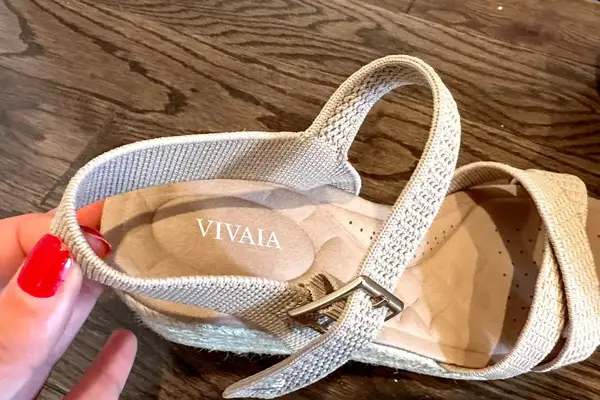 A close up of the Vivaia Round Toe Wedge Sandals sitting on a wood floor