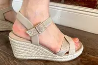 A person wearing the Vivaia Round Toe Wedge Sandals