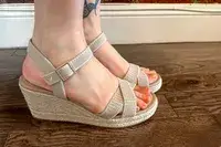 A person wearing the Vivaia Round Toe Wedge Sandals