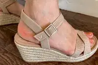 A person wearing the Vivaia Round Toe Wedge Sandals